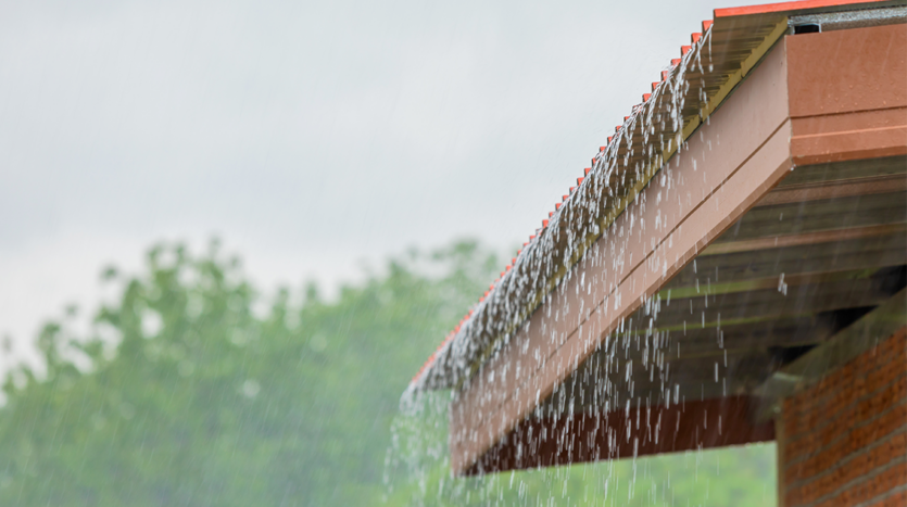 Rain pouring over the roof of a luxury villa in Phuket, showcasing effective drainage and tropical landscaping.