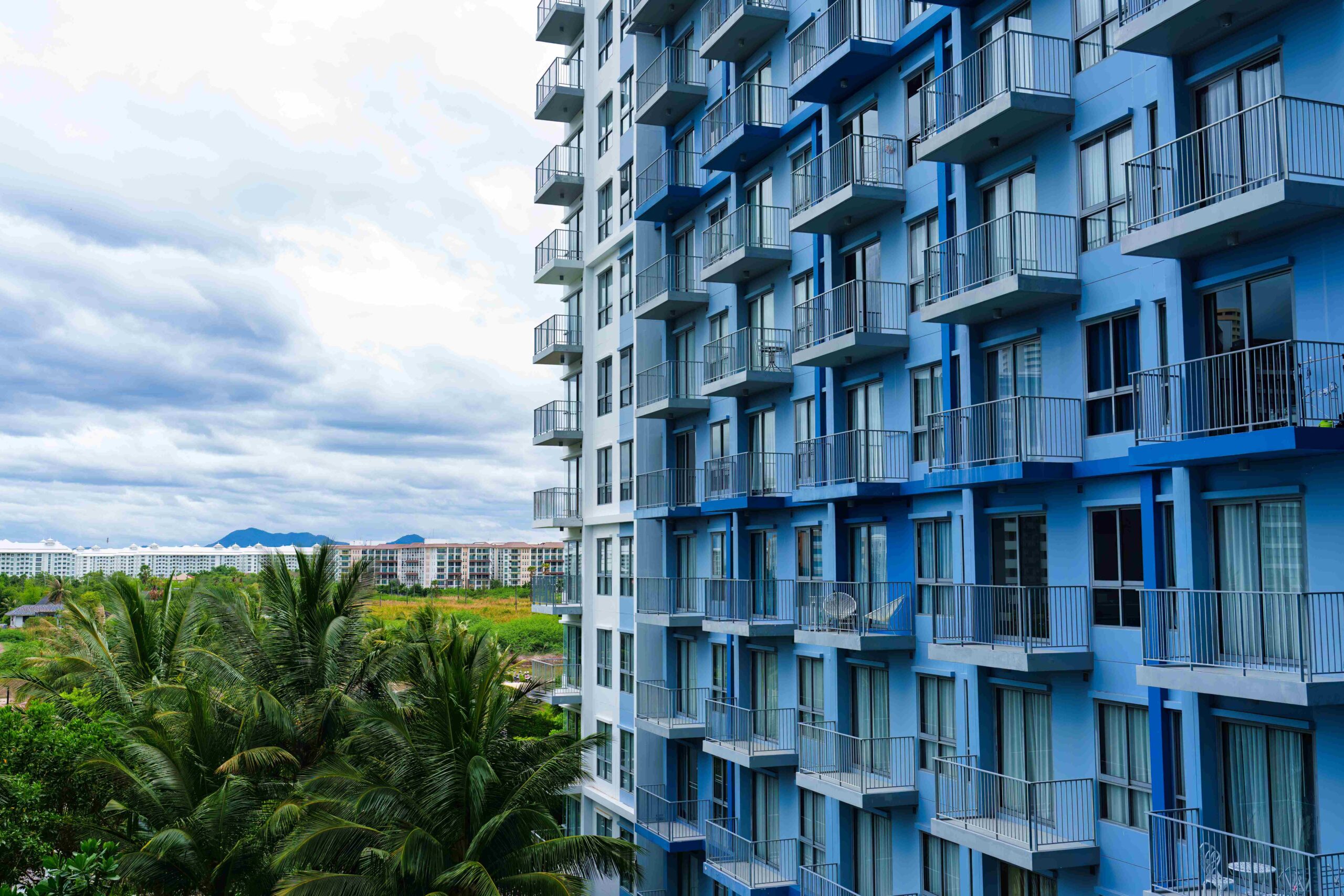 blue-facade-modern-condominium-with-balcony-and-gl-2025-03-27-02-30-28-utc_11zon