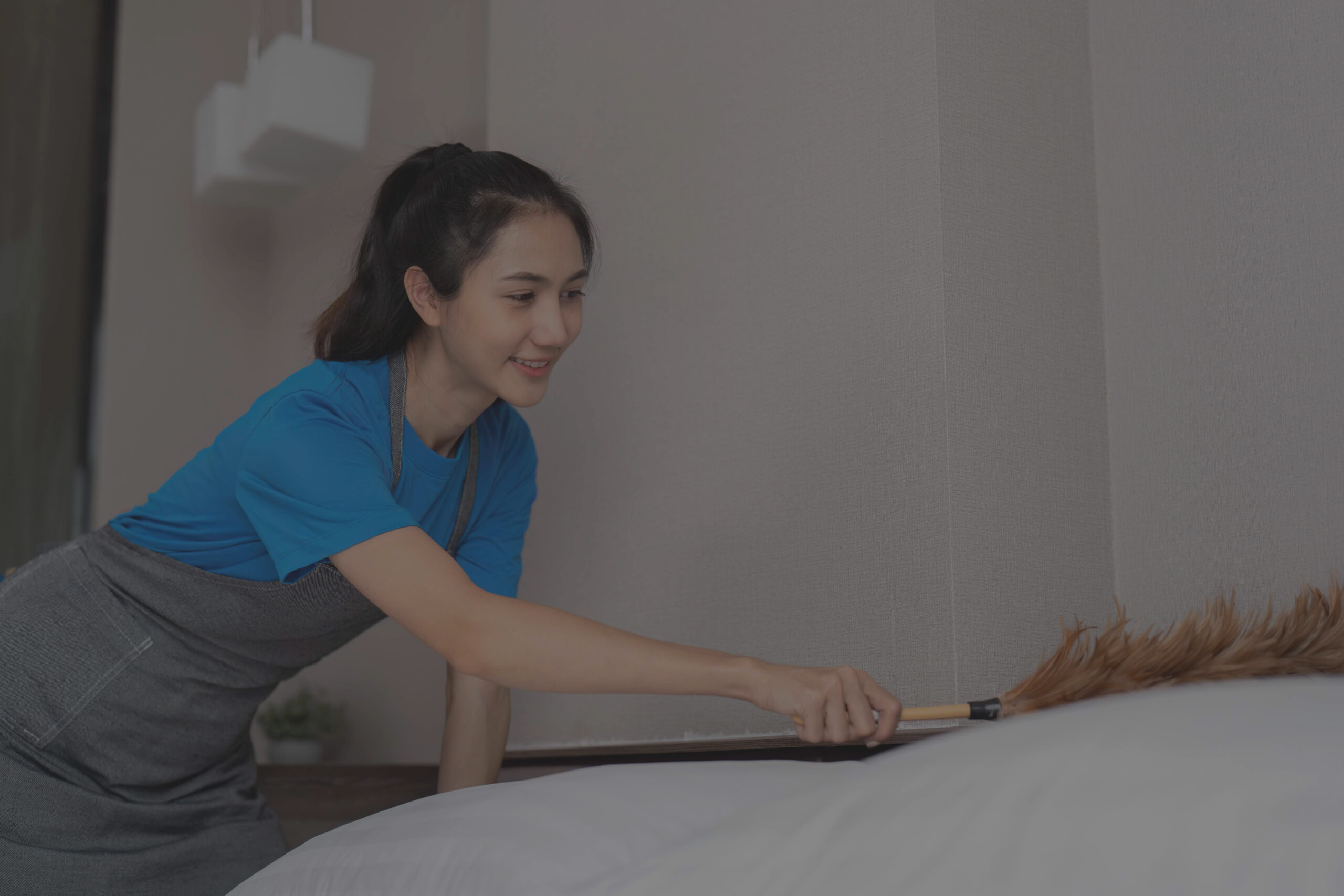 asian-housekeeper-dusting-a-bed-with-a-feather-dus-2025-01-10-12-51-42-utc_11zon