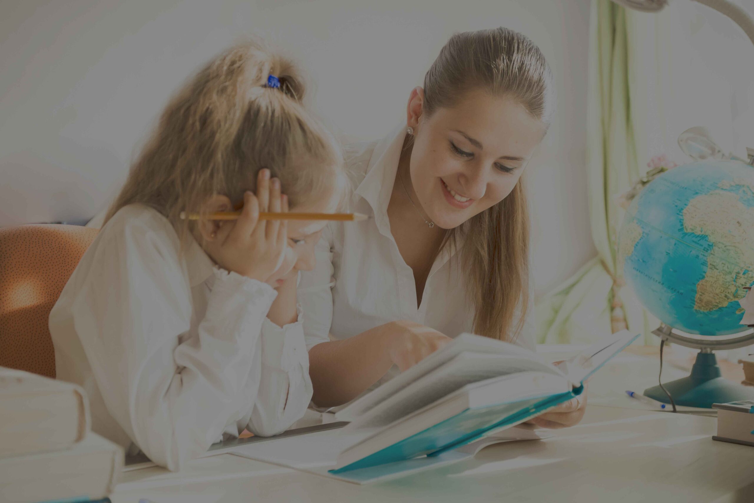 smiling-woman-reading-book-with-daughter-at-desk-2025-01-08-17-32-14-utc_11zon